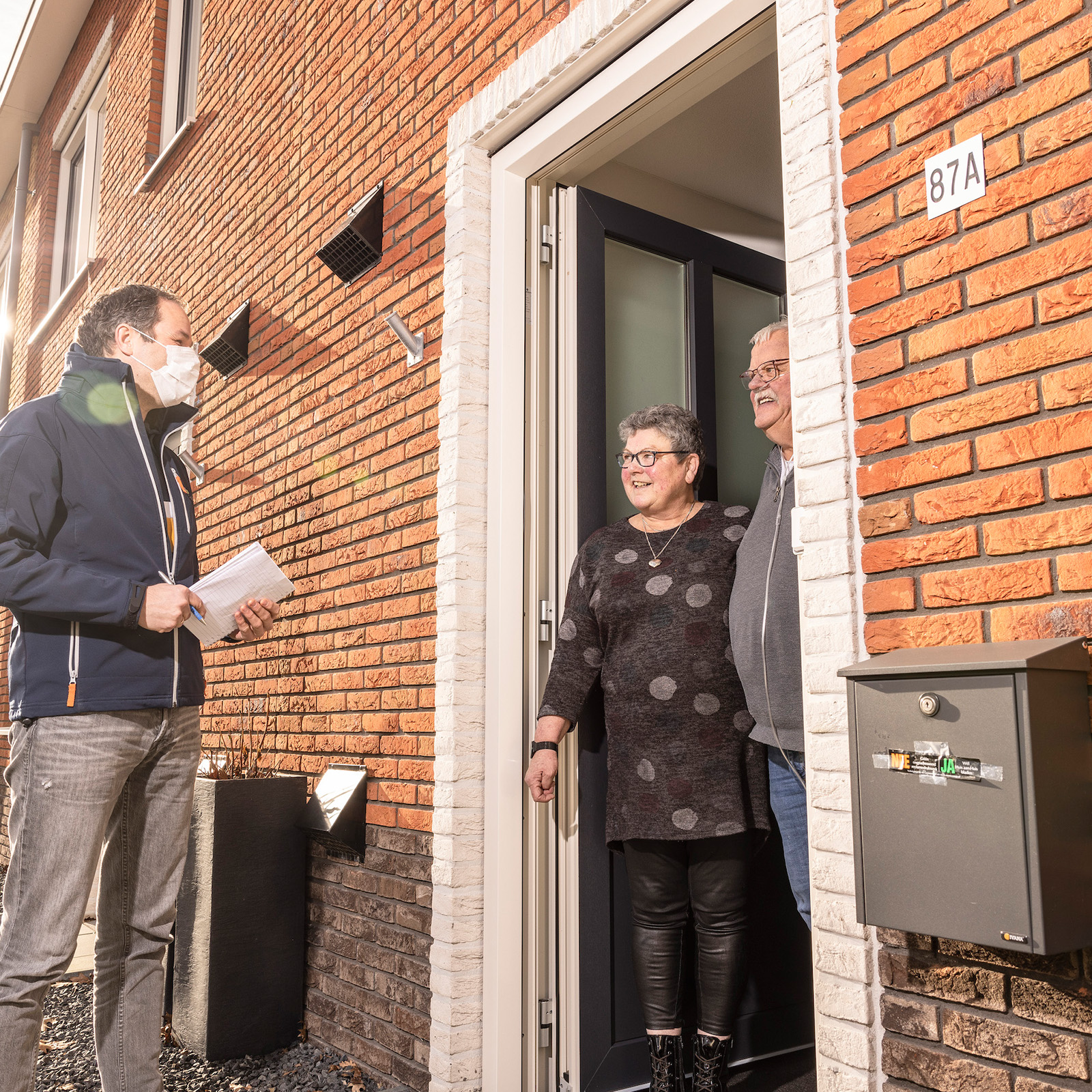 Medewerker Woonfriesland bij voordeur van huurders